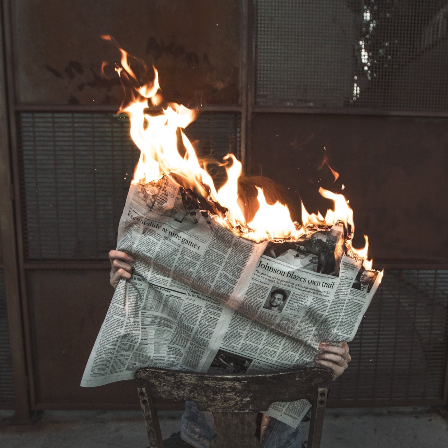 person reading burning newspaper